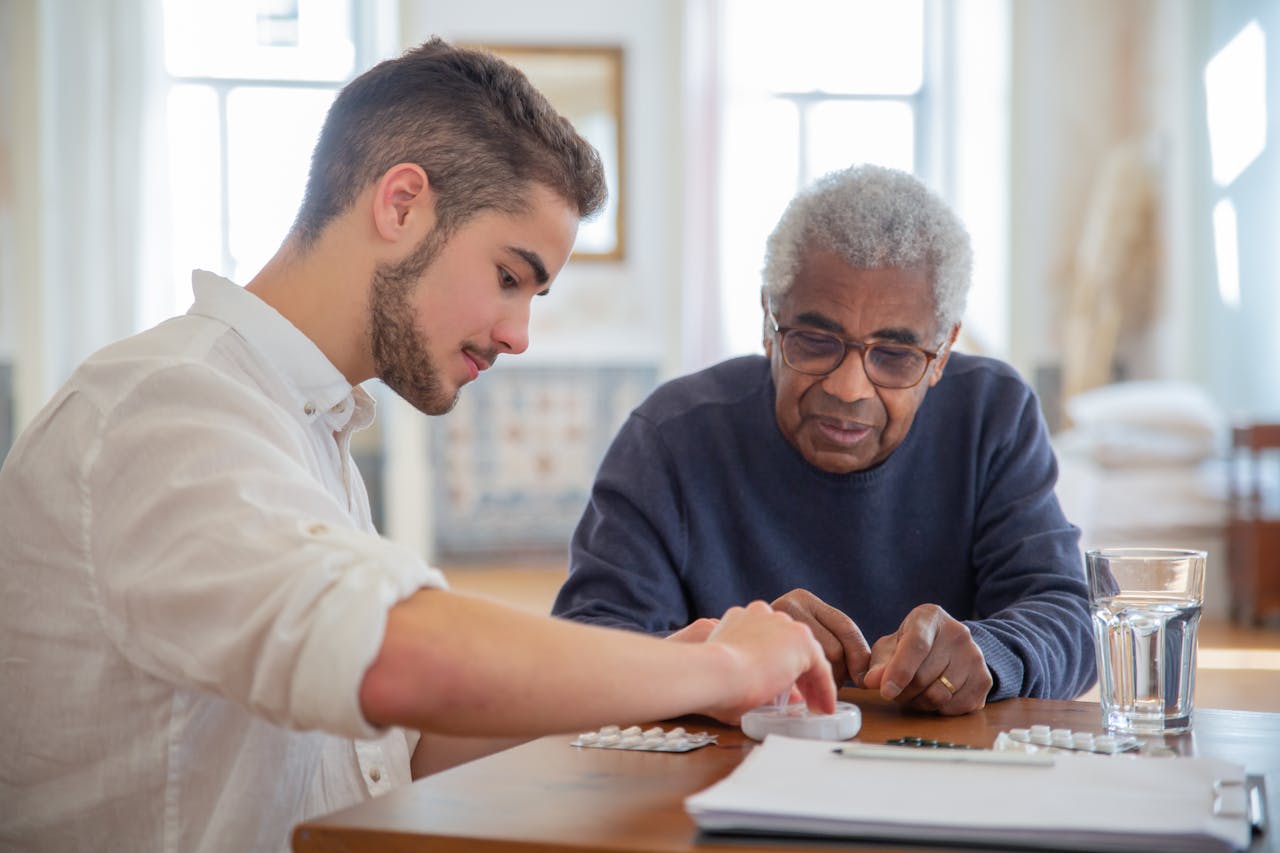 The Art of Drawing Readers In: Your attractive post title goes here A young volunteer helps an elderly man manage his medication at a nursing home.